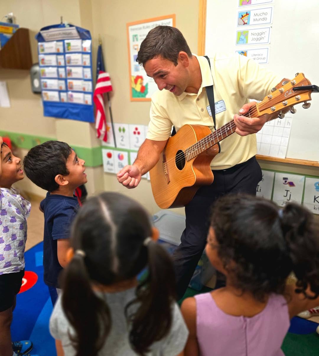 Johnny inviting a preschool child to sing into a pretend microphone during an interactive music program