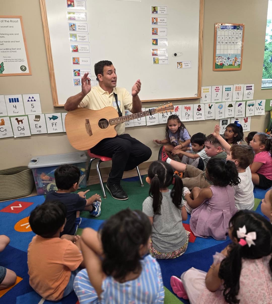 Johnny performing with a compact guitar setup for a preschool classroom